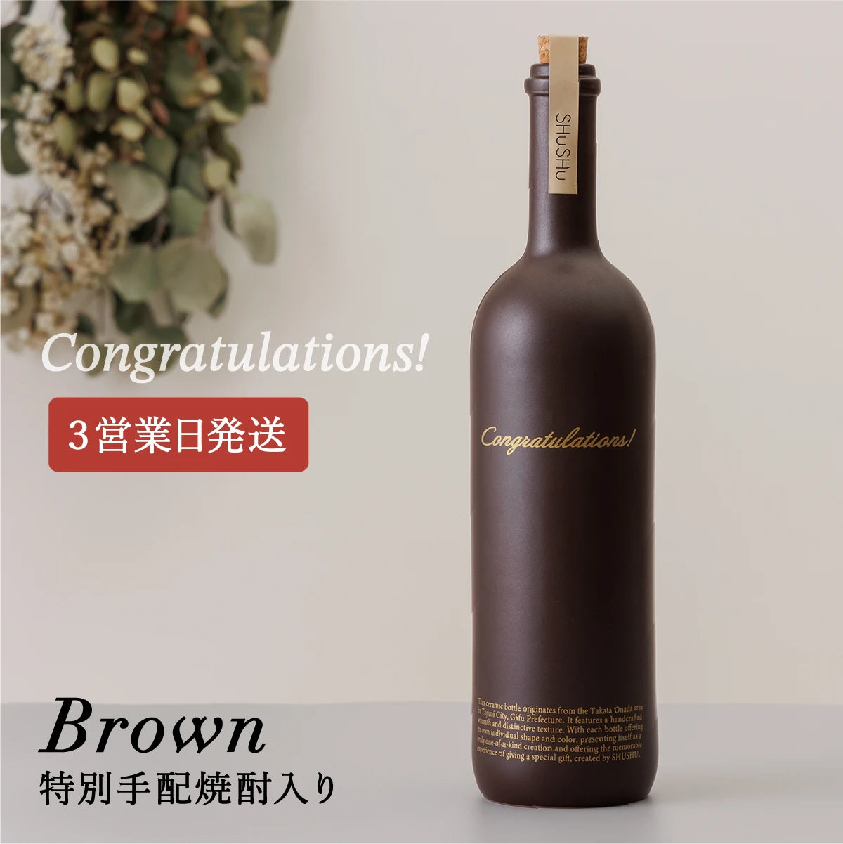 名入れ酒器ギフトSHUSHU。ブラウン色のストレート型陶器ボトル。ゴールド文字の『Congratulations』刻印入り、特別手配焼酎を詰めたギフト。3営業日発送