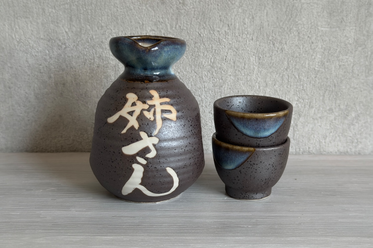 美濃焼の黒結晶名入れ徳利とおちょこのセット。職人による手書きの「姉さん」という名入れが施された、落ち着いた質感の酒器ギフト。